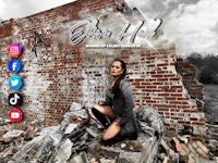 a woman is posing in front of a brick wall
